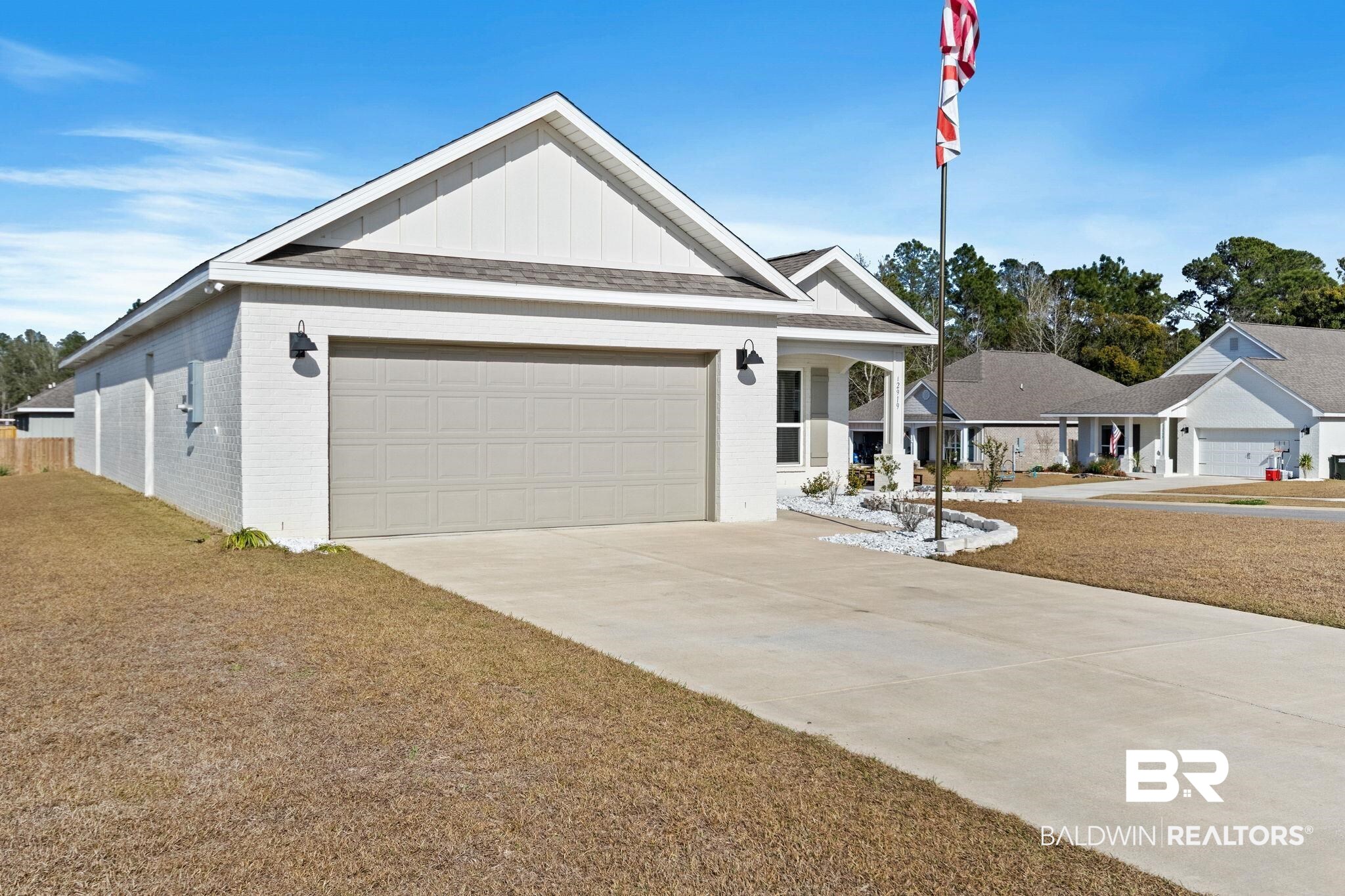 12919 Torrent Road Fairhope, AL 36532 - Photo 8 of 74 Ranch-style house featuring brick siding, board and batten siding, a garage, and concrete driveway