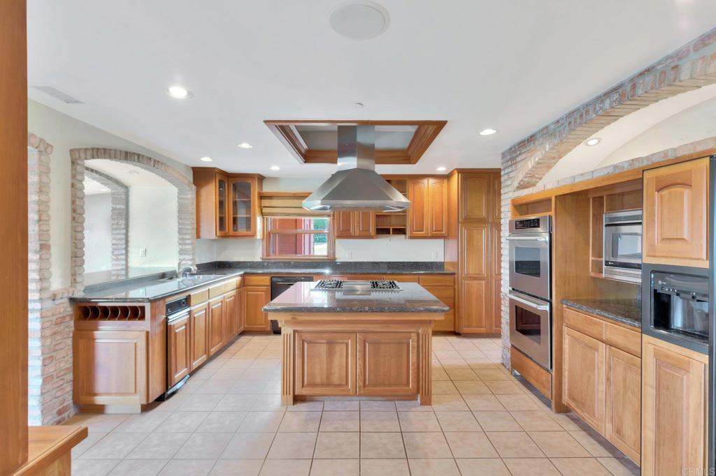1575 Crest Drive Encinitas, CA 92024 - Photo 23 of 52 a kitchen with stainless steel appliances granite countertop a stove a sink and a refrigerator
