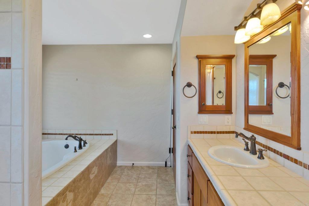 1575 Crest Drive Encinitas, CA 92024 - Photo 32 of 52 a bathroom with a tub sink and mirror