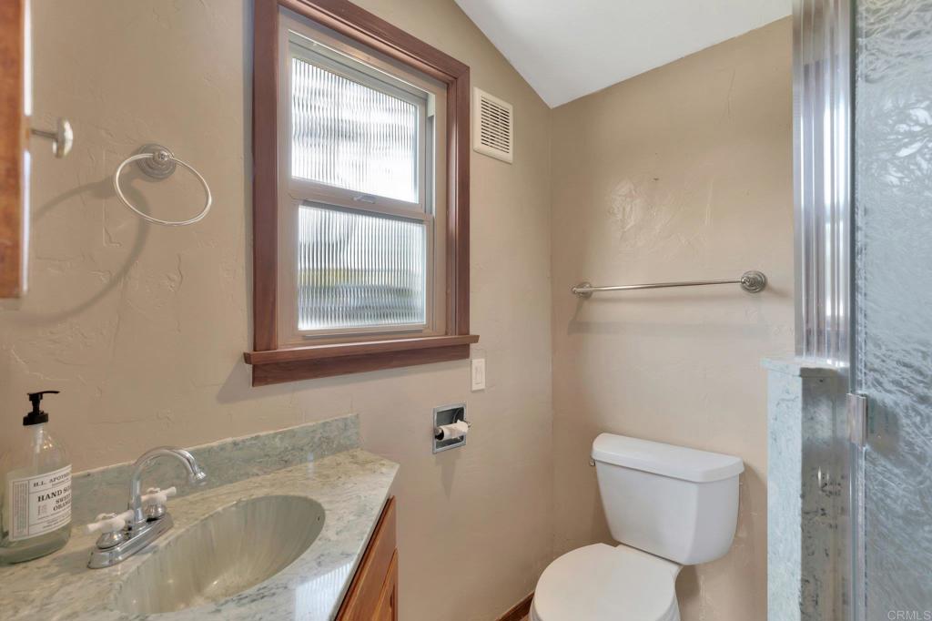 1575 Crest Drive Encinitas, CA 92024 - Photo 47 of 52 a bathroom with a toilet sink vanity and mirror