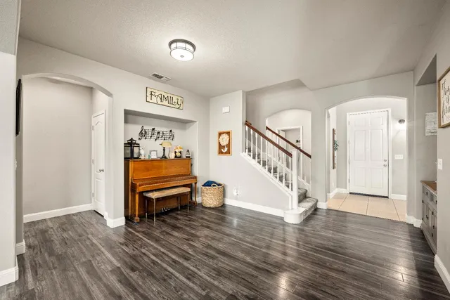 a view of a hallway with wooden floor and staircase