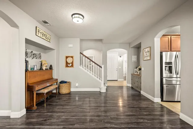 a living room with furniture a large window and wooden floor