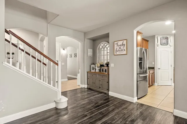 a living room with furniture and a dining table with wooden floor