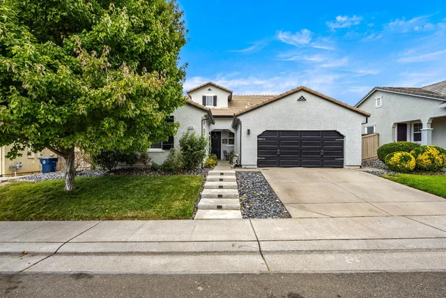 a front view of a house with a garden