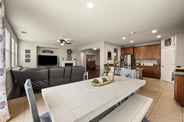 a kitchen with stainless steel appliances granite countertop a refrigerator a stove top oven and a sink with wooden floor