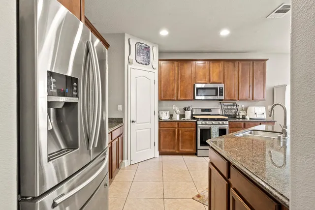 a kitchen with stainless steel appliances granite countertop a stove a washer and dryer