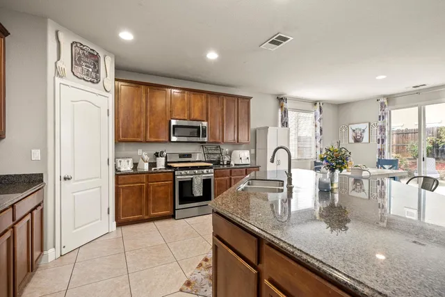 a kitchen with granite countertop cabinets stainless steel appliances and a sink