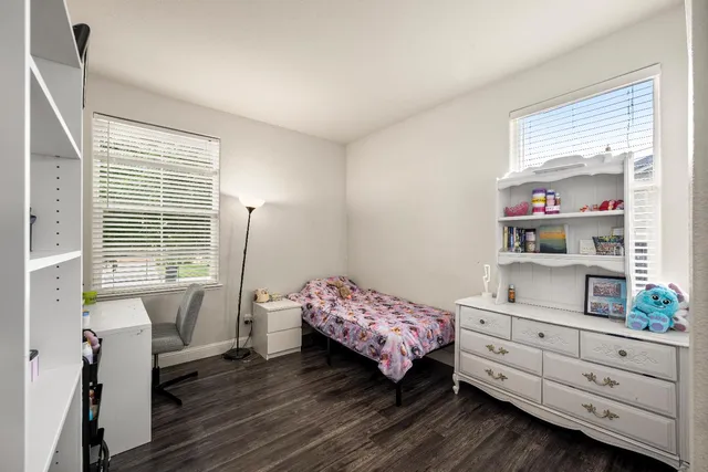 a living room with furniture and a dining table with wooden floor