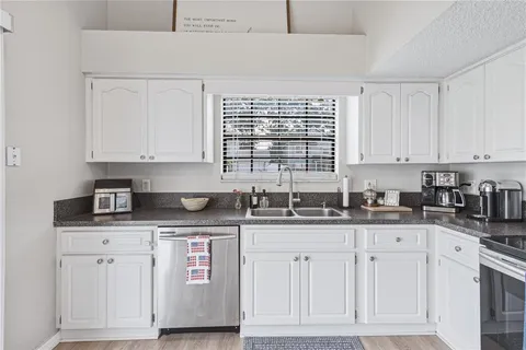 a kitchen with cabinets stainless steel appliances and a counter space