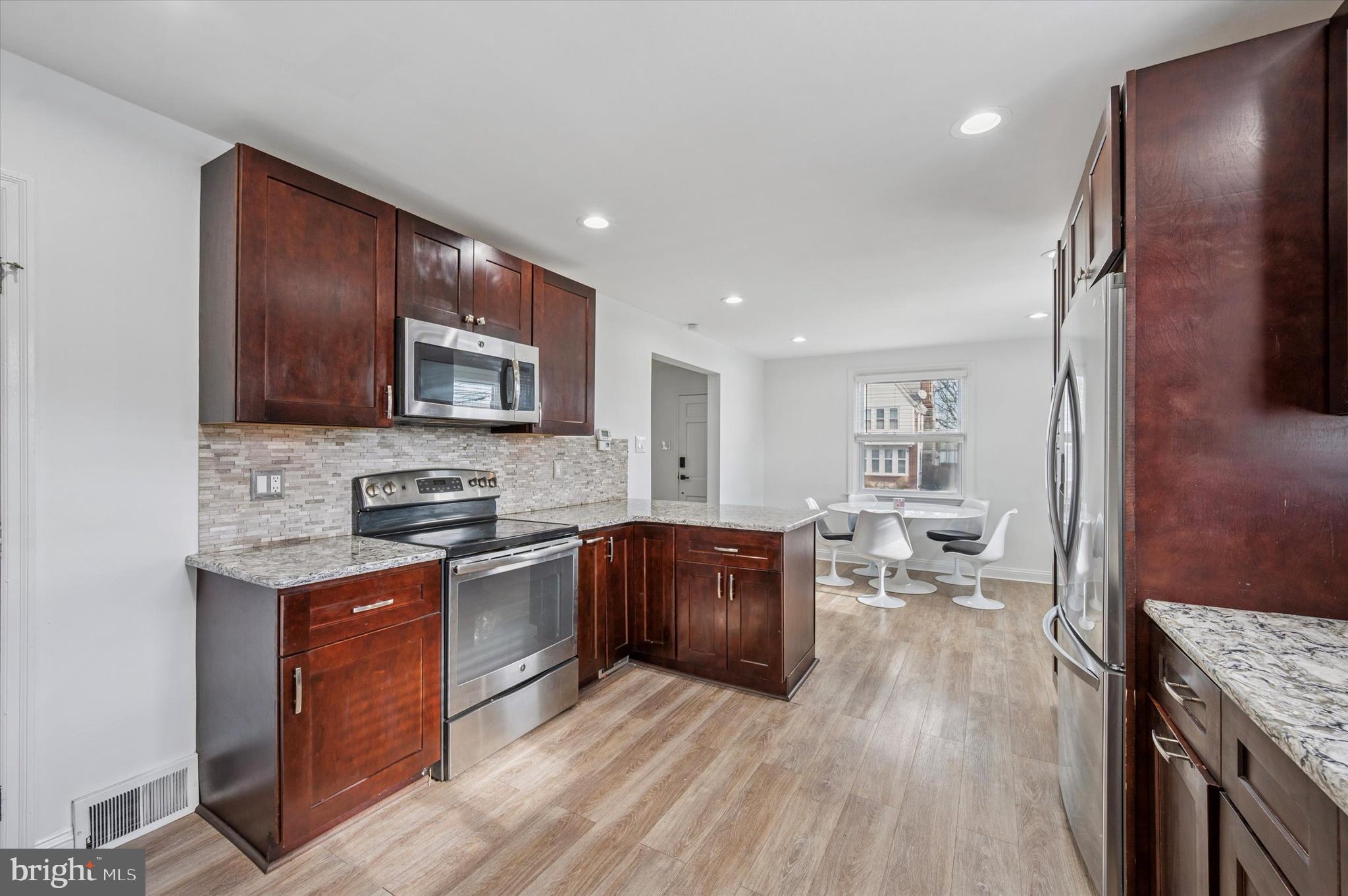 24 Upland Road Havertown, PA 19083 - Photo 14 of 28 a kitchen with stainless steel appliances granite countertop wooden cabinets a stove top oven a sink and dishwasher