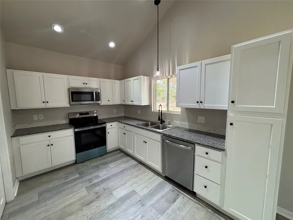 a kitchen with a sink a stove a refrigerator and cabinets