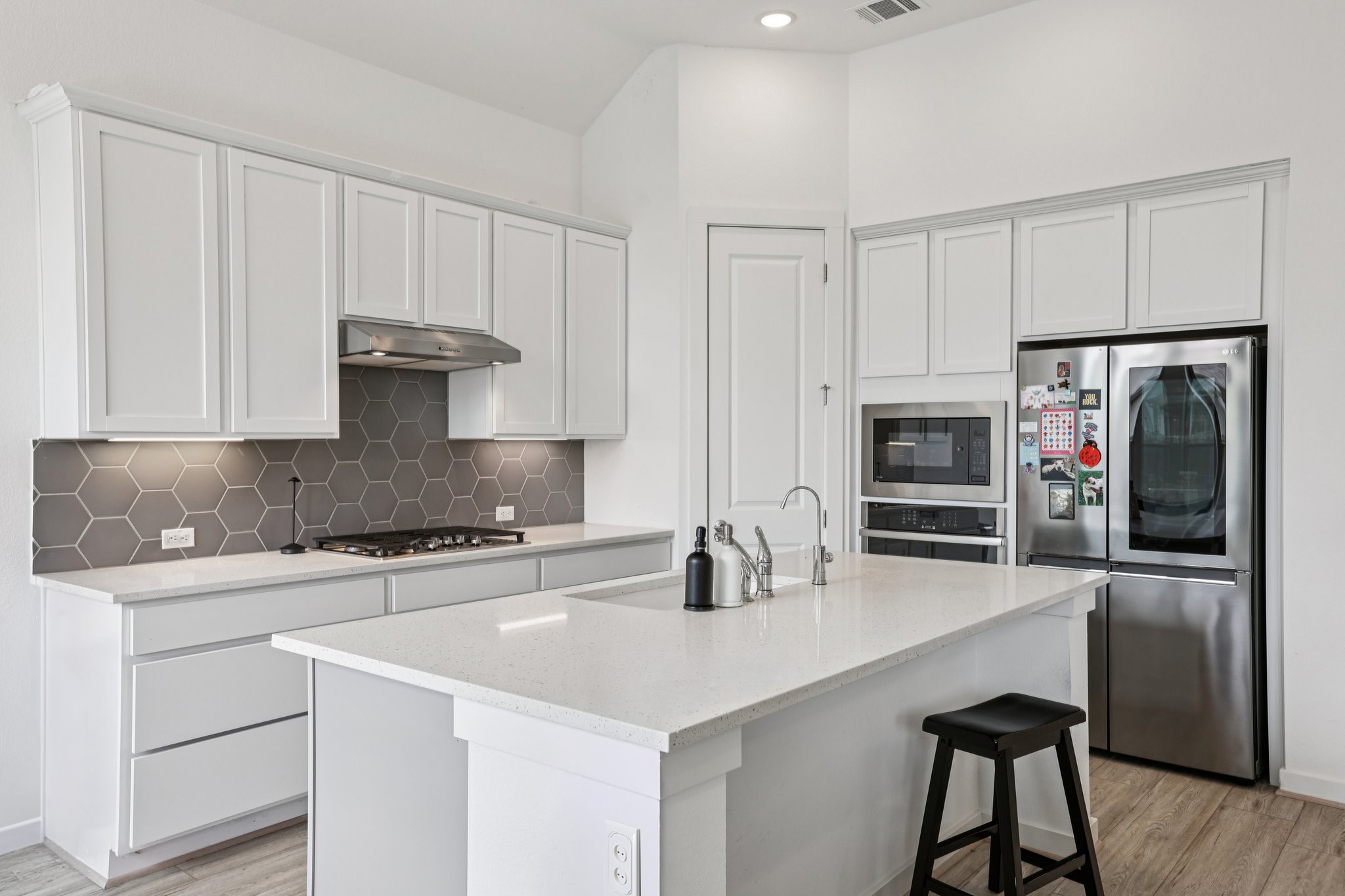 930 Nautical Loop Kyle, TX 78640 - Photo 4 of 25 Crisp white kitchen with plenty of storage cabinets, center island and miles of quartz countertops