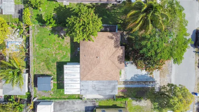 an aerial view of a house with a yard and large trees