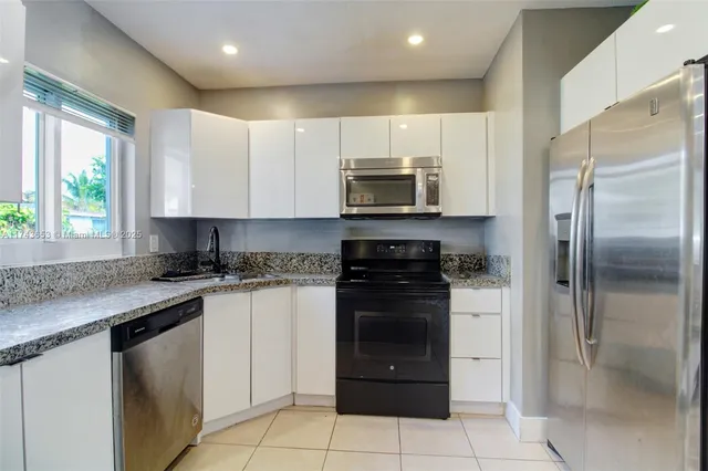 a kitchen with a refrigerator stove top oven and sink