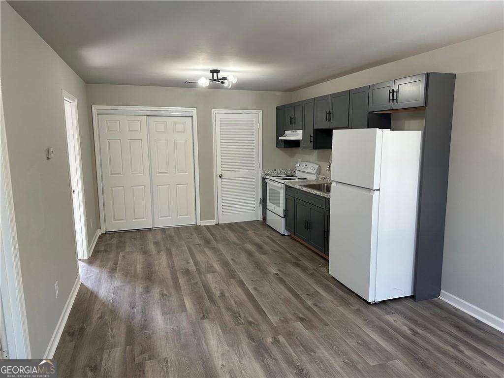 432 4th Avenue Dalton, GA 30721 - Photo 5 of 25 a view of a kitchen with a refrigerator a stove top oven and cabinets
