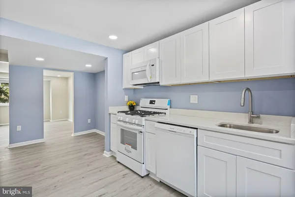 a kitchen with cabinets appliances a sink and a counter space