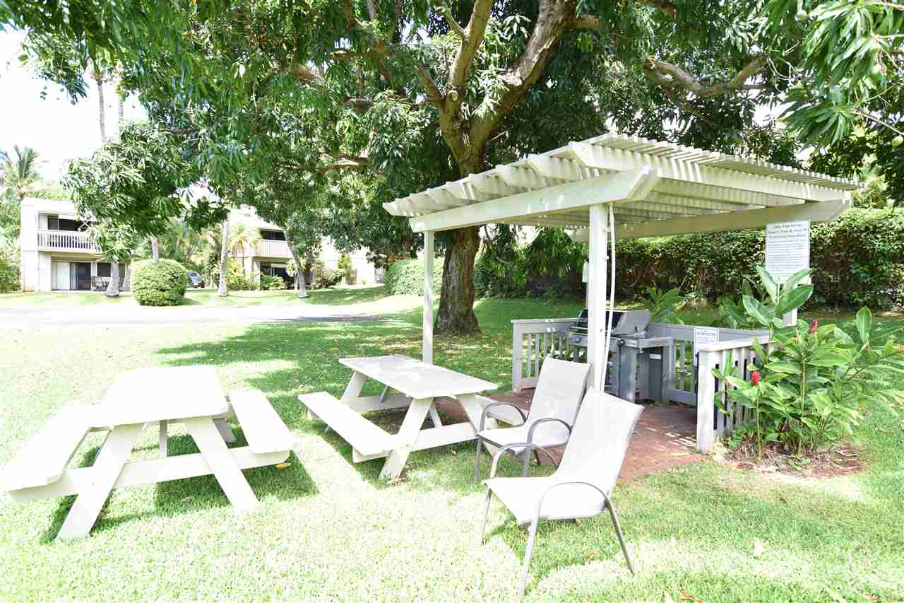 4435 Lower Honoapiilani Road, Unit 204 Lahaina, HI 96761 - Photo 19 of 23 a view of a patio with table and chairs under an umbrella