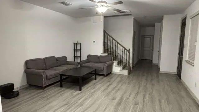 a living room with furniture and a wooden floor