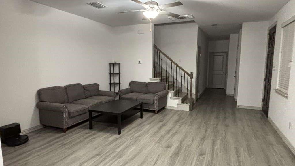 a living room with furniture and a wooden floor