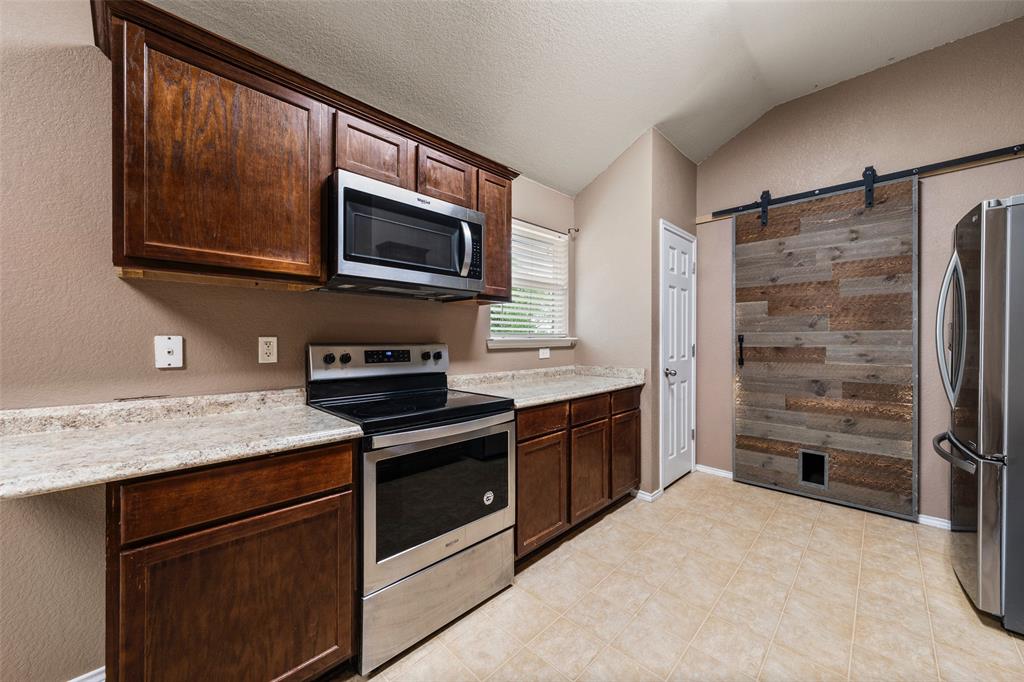 10512 Granada Drive Waco, TX 76708 - Photo 9 of 22 a kitchen with stainless steel appliances granite countertop a stove microwave and refrigerator