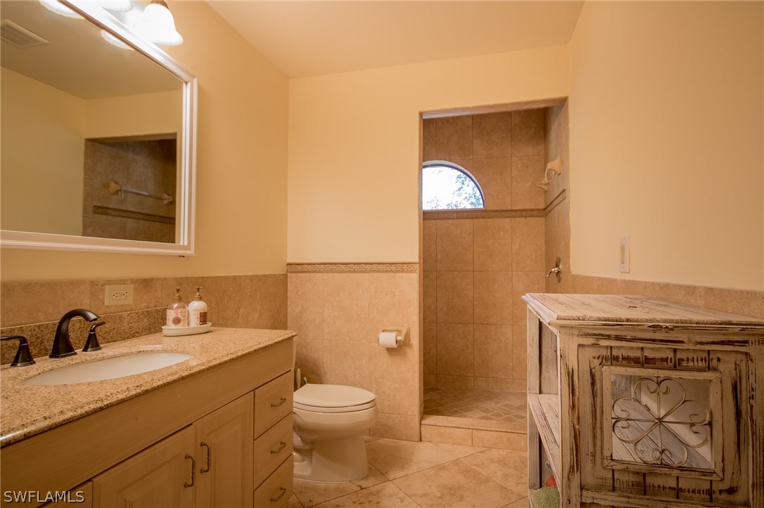 3760 Ellis Road Fort Myers, FL 33905 - Photo 8 of 25 a bathroom with a granite countertop toilet a sink and mirror