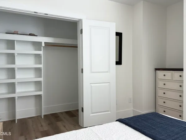 a view of a bedroom with closet and wooden floor