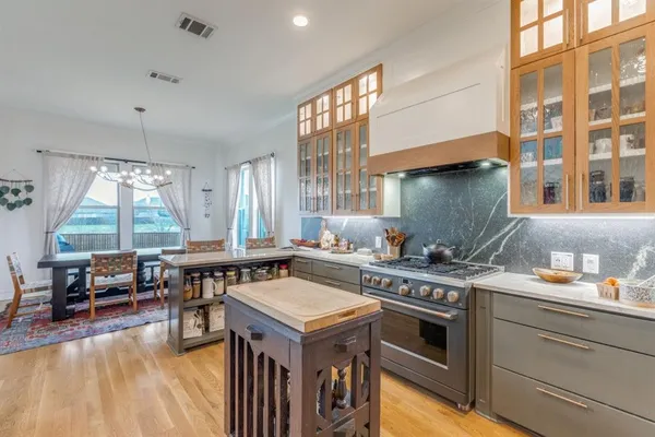 a kitchen with a stove and wooden cabinets