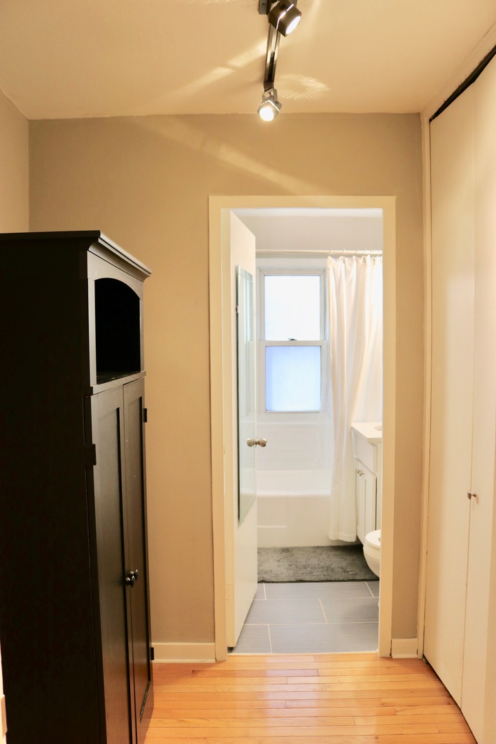 2909 North Sheridan Road, Unit 201 Chicago, IL 60657 - Photo 12 of 18 a view of a hallway with wooden floor and closet area