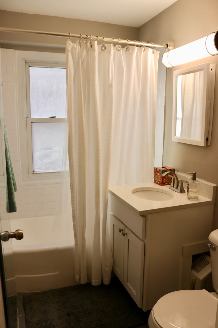 2909 North Sheridan Road, Unit 201 Chicago, IL 60657 - Photo 14 of 18 a bathroom with a granite countertop sink and a mirror