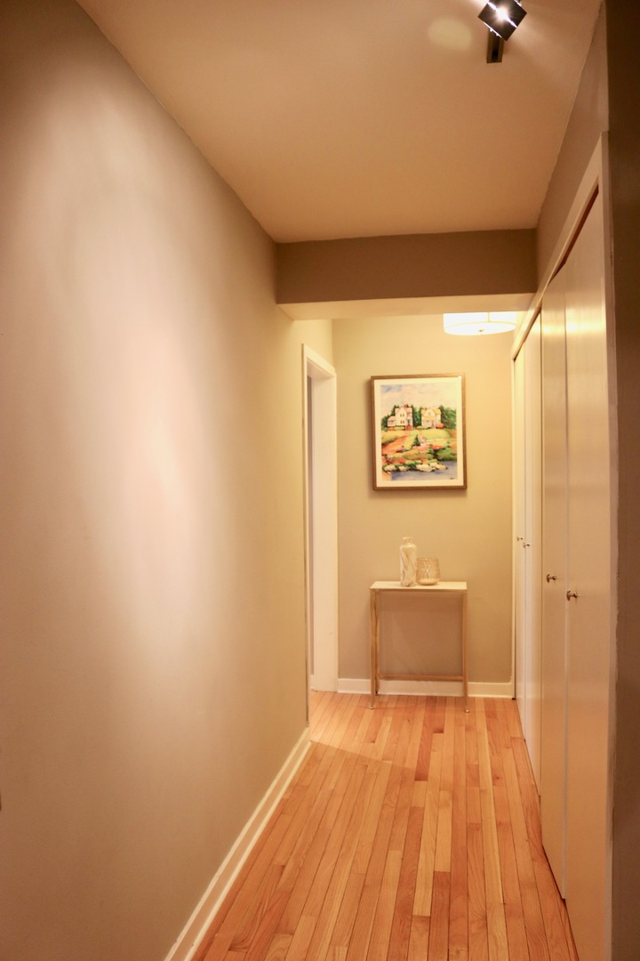 2909 North Sheridan Road, Unit 201 Chicago, IL 60657 - Photo 3 of 18 a view of a hallway with wooden floor and a bathroom
