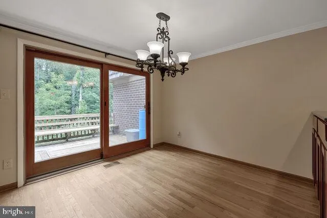 a view of a room with wooden floor fan and windows