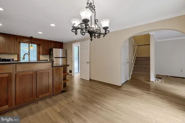 a view of a kitchen with wooden floor and a chandelier