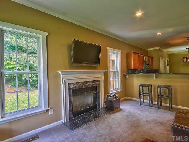 8008 Mill Bluff Court Raleigh, NC 27616 - Photo 14 of 25 a living room with furniture a flat screen tv and a fireplace
