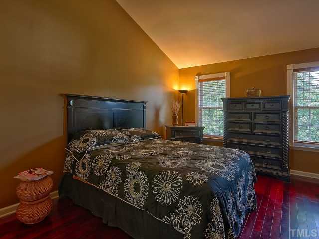8008 Mill Bluff Court Raleigh, NC 27616 - Photo 16 of 25 a bedroom with a bed and wooden floor