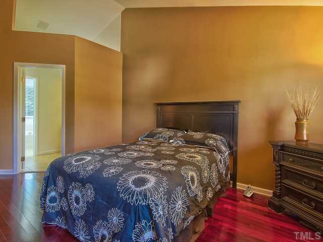 8008 Mill Bluff Court Raleigh, NC 27616 - Photo 17 of 25 a bedroom with a bed and wooden floor