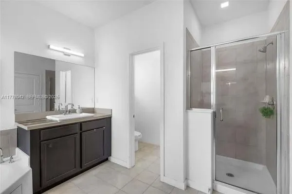 a bathroom with a granite countertop sink shower and mirror