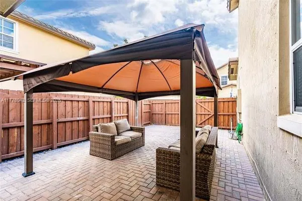 a backyard of a house with wooden floor and outdoor seating