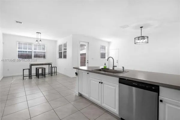 a kitchen with a sink and chairs