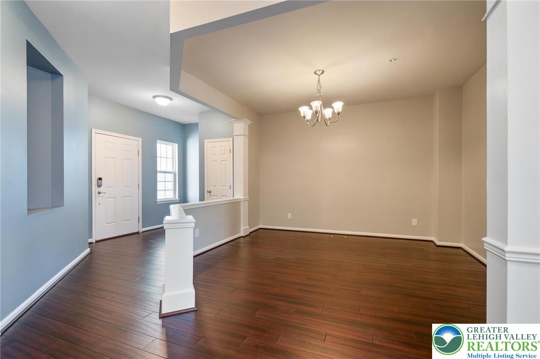 8455 Starling Road Breinigsville, PA 18031 - Photo 4 of 24 Rich hardwood floors welcome you into this spacious, naturally illuminated living area, anchored by a classic chandelier.
