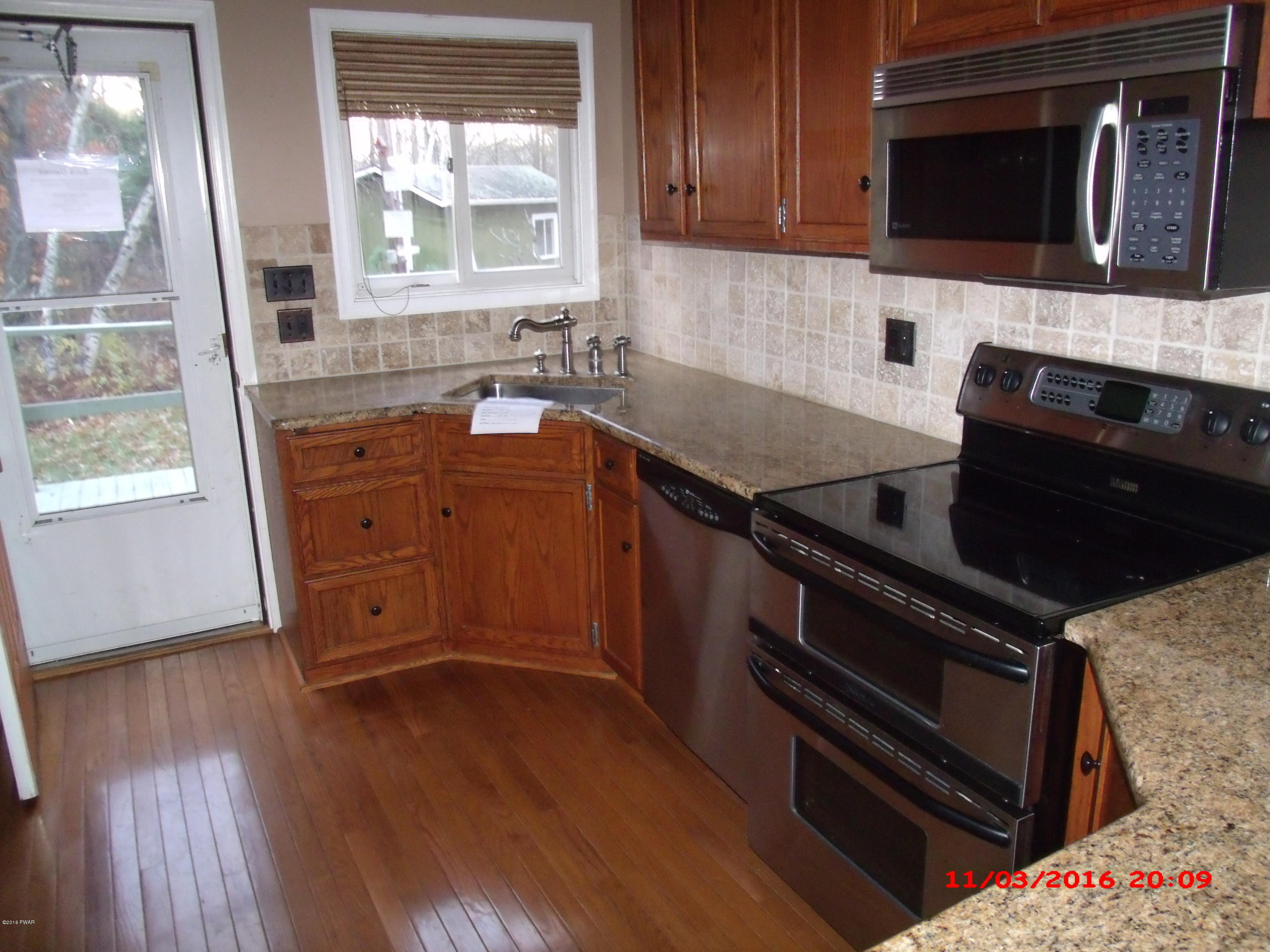 397 Perkins Pond Road Beach Lake, PA 18405 - Photo 8 of 25 a kitchen with wooden cabinets and a stove top oven