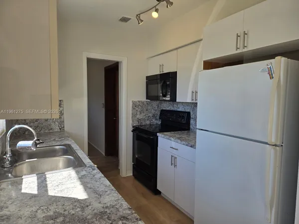a kitchen with a refrigerator sink and stove