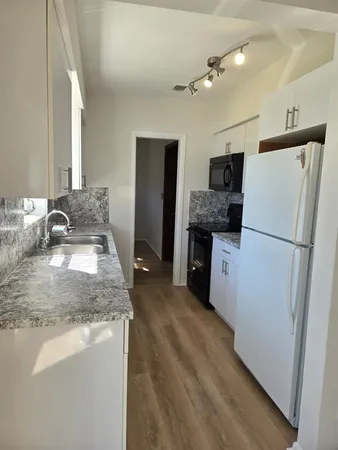 a kitchen with a refrigerator sink and stove
