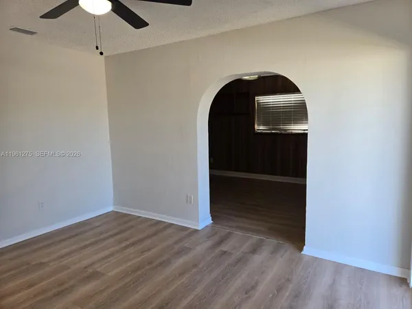 a view of empty room with wooden floor