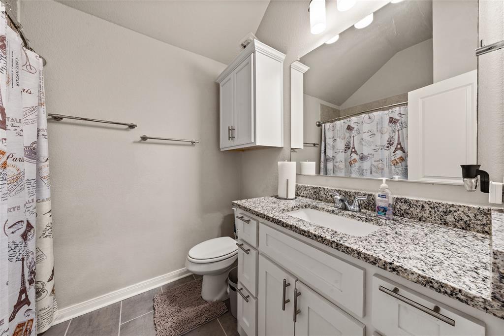 3525 Beutel Road Lorena, TX 76655 - Photo 27 of 34 a bathroom with a granite countertop sink a toilet and a shower