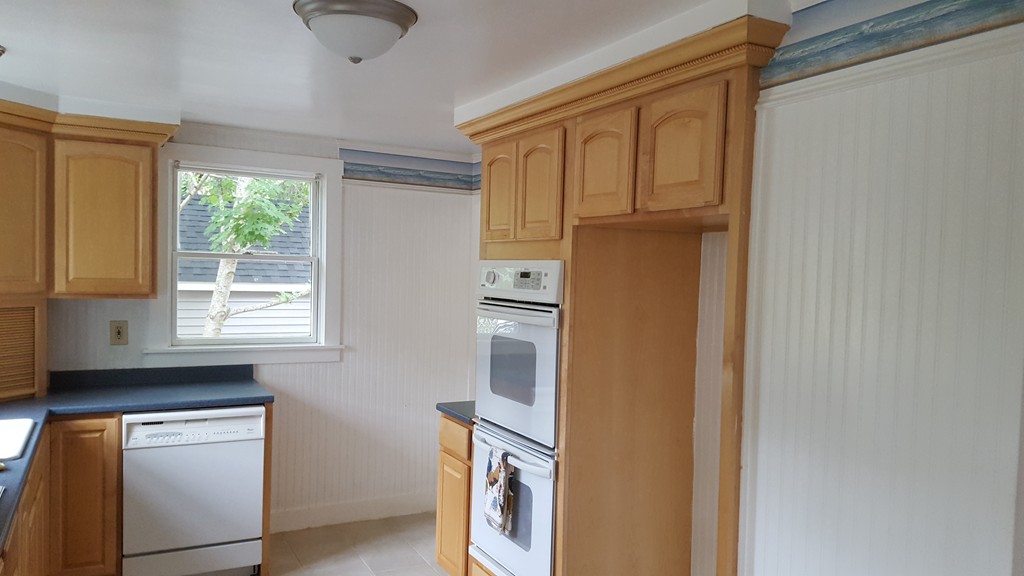 32 Puritan Road Bourne, MA 02532 - Photo 4 of 10 a kitchen with a refrigerator and cabinets