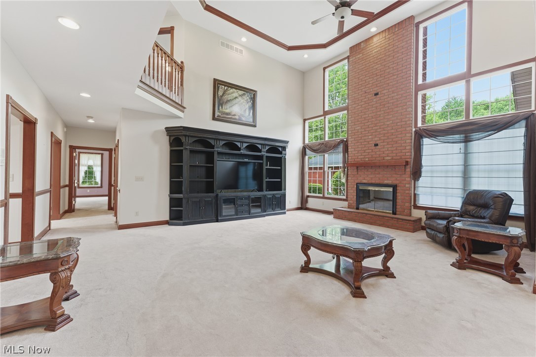 2184 Brenner Road Northeast Carrollton, OH 44615 - Photo 7 of 50 Two-story living area featuring a prominent brick fireplace, vaulted ceilings with wood trim accents, and a built-in entertainment center