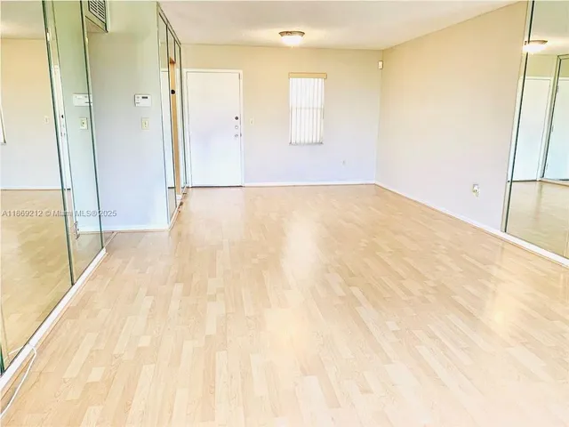 a view of a room with wooden floor and a bathroom space