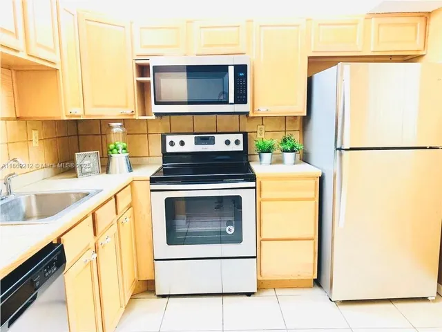 a kitchen with a refrigerator sink and stove