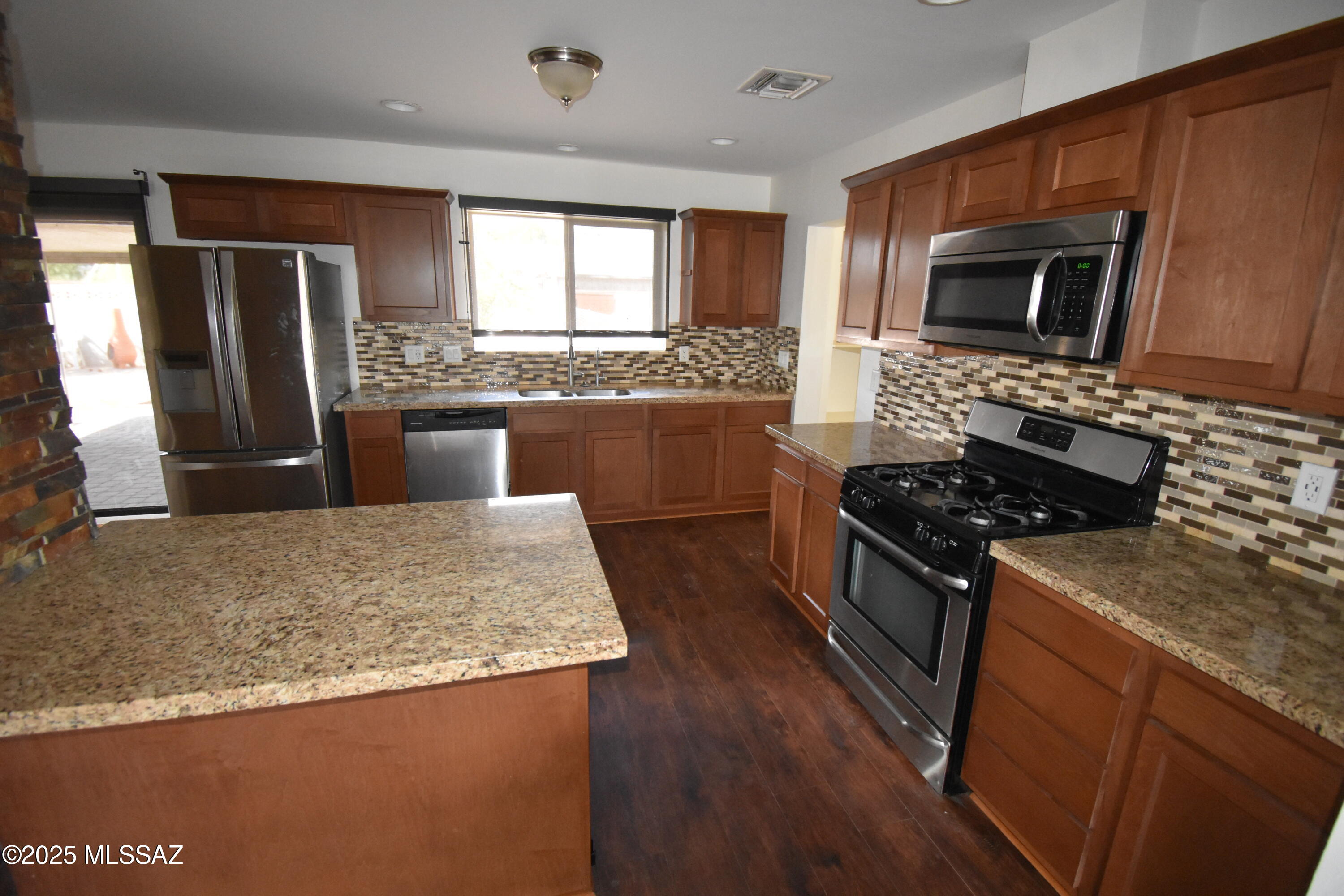 5501 East Spring Street Tucson, AZ 85712 - Photo 17 of 32 a kitchen with stainless steel appliances granite countertop a stove a sink and a refrigerator