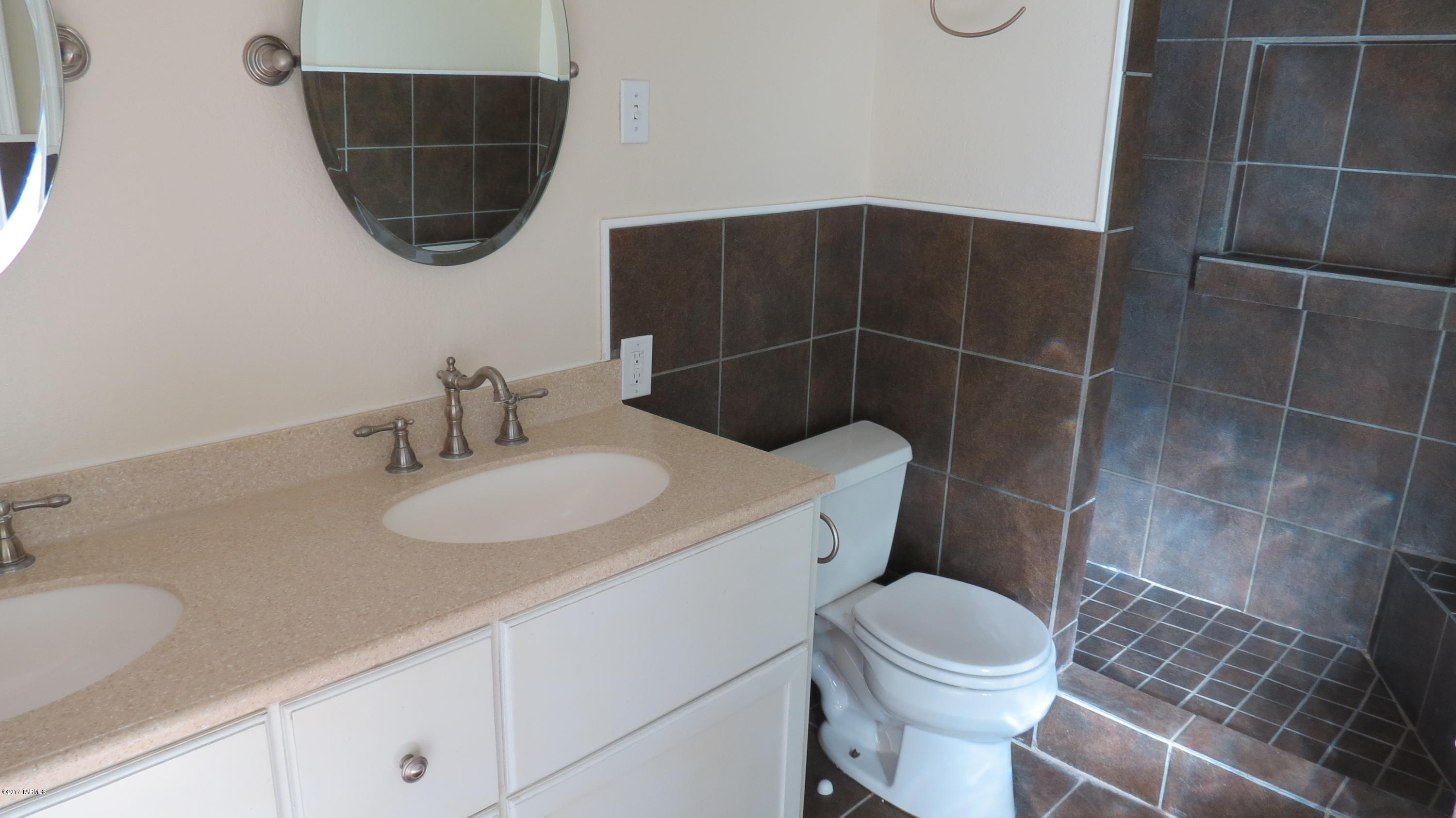 6601 North Mona Lisa Road Tucson, AZ 85741 - Photo 10 of 23 a bathroom with a sink a toilet and a mirror
